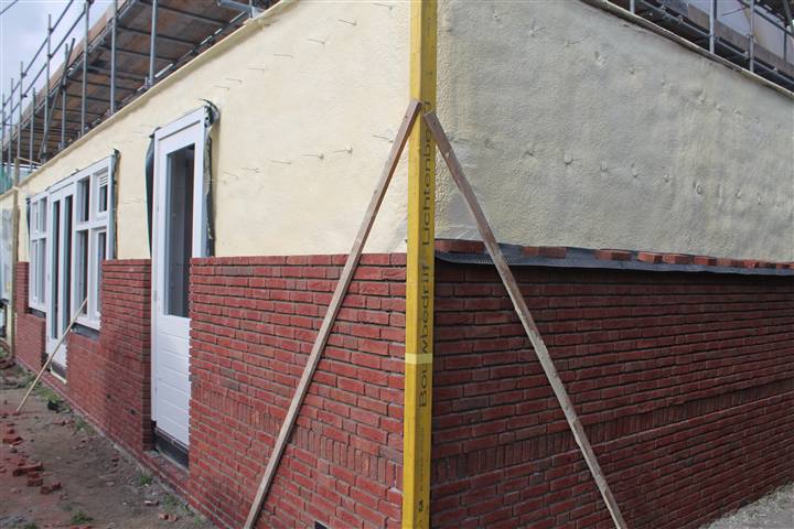 Mit Sprühschaum gedämmte Fassade vor dem Aufmauern der Klinker-Verblendung